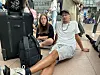 Ein Vater-Tochter-Gespann sitzen auf dem Boden des Terminals.