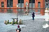 Passanten beobachten eine Sturmflut auf dem Hamburger Fischmarkt (Archivbild).
