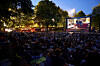 Openair-Kino bei Nacht, hinten Leinwand, davor das Publikum