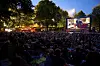 Openair-Kino bei Nacht, hinten Leinwand, davor das Publikum