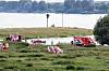 Einsatzkräfte der Polizei, Feuerwehr und DRLG arbeiten am Ufer des Rheins.