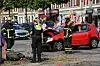 Feuerwehrleute und eine Polizistin stehen neben einem der beiden Unfallautos.