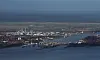 Die Schleuse zwischen Elbe und Nord-Ostsee-Kanal (NOK) in Brunsbüttel mit der Stadt Brunsbüttel (vorne, l), und dem Chemiewerk Sasol (hinten, l).