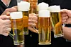 Menschen prosten sich mit Bier zu.