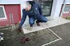 Ein Polizist untersucht die Blutlache am Tatort in Rostock.