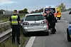 Polizeikräfte schieben den Wagen von der Planke weg.