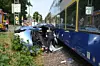 Eine Polizistin sieht in ein zerstörtes Auto, das neben dem Gleis liegt