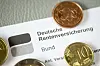 Schreiben der Deutschen Rentenversicherung zwischen Münzen als Symbol für steigende Renten.