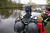Ein Taucher der Hamburger Feuerwehr steht am Ufer der Alster