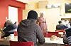 Eine Frau sitzt beim Frühstück im Speisesaal des CaFée mit Herz