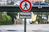 Ein Schild mit der Aufschrift „Hochwasser“ steht vor einem Flussufer in Bayern.