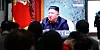 Menschen schauen auf einen Bildschirm im Bahnhof Suseo, auf dem ein Dateibild des nordkoreanischen Machthabers Kim Jong Un während einer Nachrichtensendung gezeigt wird.
