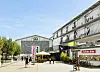 So soll die Kampnagel-Piazza einmal aussehen: Die neue Halle (r.) soll auf Stelzen über das bestehende Gebäude mit Kino, Restaurant und Haupteingang gebaut werden.