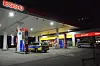 Eine Esso-Tankstelle, zwei Streifenwagen der Polizei stehen davor.