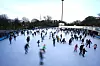 Viele Menschen fahren auf der Eisbahn im Park „Planten un Blomen“ Schlittschuh