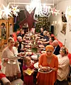 Dietmar und Martina Sawatzke sitzen mit Familie und Freunden unter Weihnachtssternen am festlich gedeckten Tisch