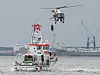 Ein Rettungshubschrauber lässt am Tag der Seenotretter auf der Elbe bei einer Winschübung einen Helfer zum Seenotrettungskreuzer Anneliese Kramer herab.