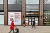 Menschen laufen auf der Mönckebergstraße in Hamburg an einem geschlossenen Geschäft vorbei.
