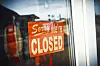Schild mit der Aufschrift „Sorry we‘re closed“ hängt in einem Schaufenster,