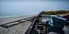 Zwei Besucher sitzen am menschenleeren Strand von Tantum auf Sylt.