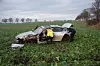 Polizisten schauen sich den BMW an, der nach dem Unfall auf einem Feld stehen blieb.