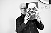 Künstler André Heller mit einem Foto von Komiker Karl Valentin. Dessen Ausspruch „Fremd ist der Fremde nur in der Fremde“ macht Heller zum Motto seines „Reflektor“-Festivals.