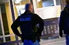 Ermittler stehen vor der Durchsuchung an einem Mehrfamilien-Hochhaus.