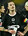 Jackson Irvine hält eine Trinkflasche und sieht erschöpft aus