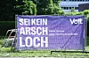 Violettes Wahlplakat: „Sei kein Arschloch“