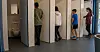Jungen und Mädchen gehen in eine Unisextoilette