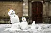 Eine Familie von Schneemännern vor einem Gebäude (Symbolbild)