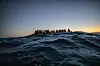 Migranten aus verschiedenen afrikanischen Nationen warten in einem Boot auf Helfer