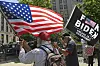 Männer in Baseball-Kappen schwenken Anti-Biden-Flagge