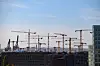 Zahlreiche Baukräne vor blauem Himmel im Stadtteil Hafencity.