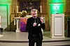 Mann in schwarzem Anzug vor einem Kirchenaltar