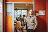 Der Leiter des KiFaZ Café in Barmbek, Olaf Sobczak steht in der Tür des Cafés. Im Hintergrund sind mehrere Besucher:innen zu sehen.