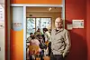 Der Leiter des KiFaZ Café in Barmbek, Olaf Sobczak steht in der Tür des Cafés. Im Hintergrund sind mehrere Besucher:innen zu sehen.