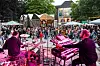 Im Vordergrund eine Bühne mit Musikern, hinten stehendes Publikum