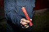 Mann hält an Silvester einen großen Böller im Freien in der Hand
