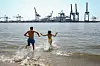 Zwei Menschen rennen in die Elbe.