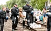 Klima-Aktivisten, die aus Protest Gleise im Hamburger Hafen besetzt haben, werden einzeln von Polizeibeamten weggetragen.