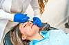 Kosmetikerin bei der Botox Injektion in das Gesicht einer Frau