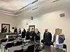Die drei Angeklagten verbergen ihre Gesichter hinter Akten.