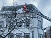 Die Feuerwehr befreit ein Dach an der Rothestraße vom Schnee.