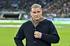 Stefan Kuntz guckt als TV-Experte am Spielfeldrand an der Kamera vorbei