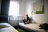 Obdachloser sitzt auf einem Hotelbett in Hamburg