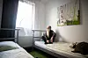 Obdachloser sitzt auf einem Hotelbett in Hamburg