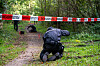 Ein Polizist sichert Spuren in einem Waldstück zwischen Büchen und Witzeeze