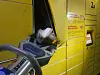 Die Füße eines Jugendlichen ragen aus dem Schließfach einer Packstation.