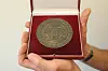 Die massive Bronze-Medaille für „treue Arbeit im Dienste des Volkes“ einem roten Etui mit dem Großen Hamburger Staatswappen